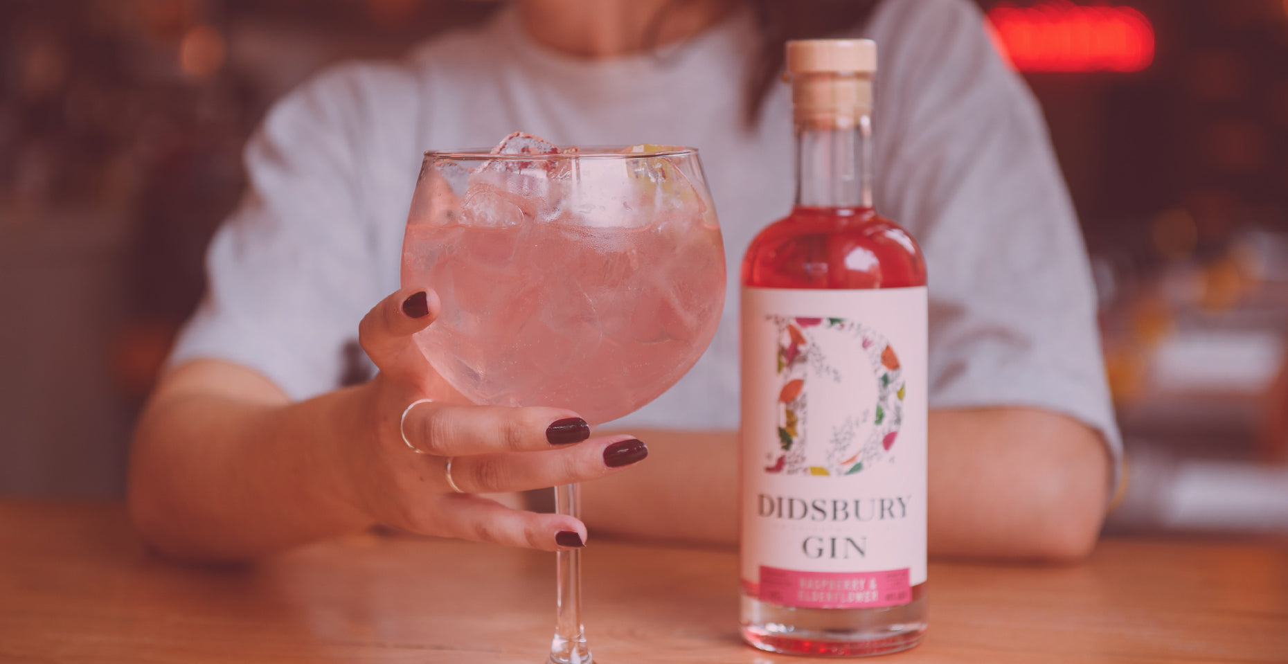 A bottle of Didsbury Gin Raspberry and Elderflower and a cocktail.